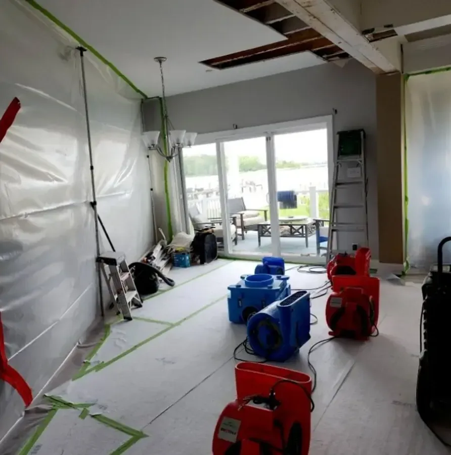 Plastic containment and air movers set up to dry a hallway after a supply leak