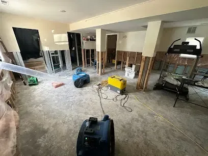 Drying equipment running in a basement family room with the lower walls opened