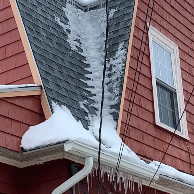 Packed snow and ice built up along a roof edge and its gutter