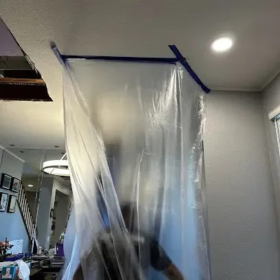Sewage backup work area sealed off with containment inside a house