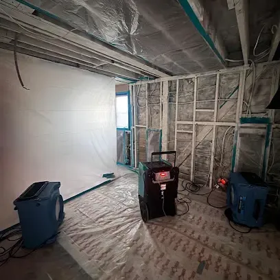 Water pooled around a failed water heater on a garage floor